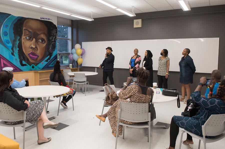 A group of individuals are in the Community Room for a presentation.  Open Gallery